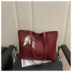 Detail of burgundy large tote bag in soft PU leather with silk scarf and metal logo