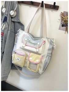 Detail of multi-pocket canvas bag with pastel color blocking and wide shoulder straps