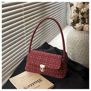 Dettaglio della borsa a tracolla in tweed rosso con fibbia dorata in scena elegante