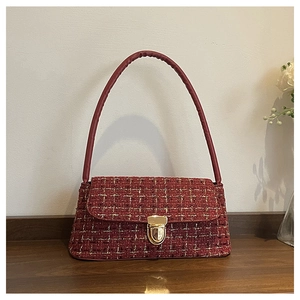 Dettaglio della borsa a spalla in tweed bordeaux con trama rosso-oro e chiusura oro