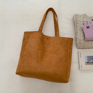 Detailed texture of brown corduroy tote bag styled with cozy winter accessories