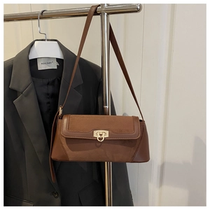 Detail of suede and leather patchwork crossbody bag with elegant gold metal buckle