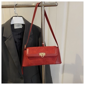 Detail of red crossbody bag with matte leather panels and vintage gold metal lock