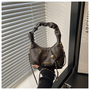 Détail du sac nuage en cuir marron foncé avec poignée plissée et chaîne dorée