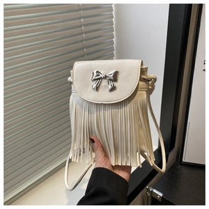 Detail showing cream white fringe shoulder bag with silver bow hardware and tassels