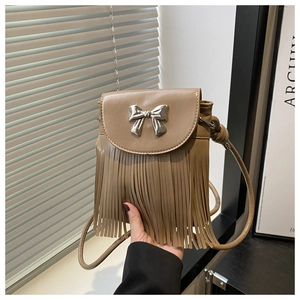 Close-up of khaki leather crossbody bag featuring silver bow buckle and long fringe tassels