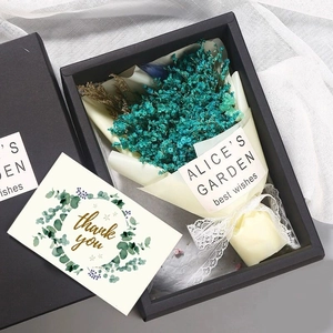 Close-up of teal dried flowers in black gift box with a greenery Thank You card