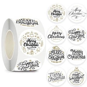 Roll of Merry Christmas stickers featuring gold, black, and white holiday patterns