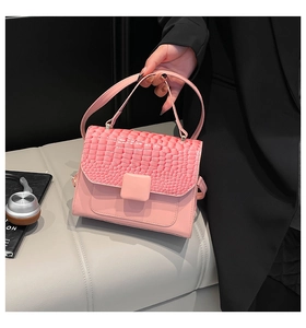 Detail of light pink crossbody bag with crocodile embossed flap and square buckle