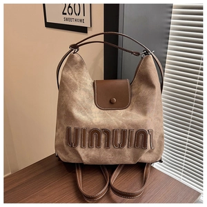 Detail of retro brown tote bag with embossed lettering and fine white stitching on leather