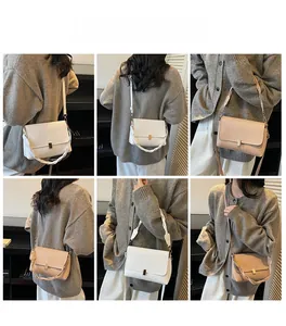 Model wearing minimalist leather crossbody bag with gold buckle in white and apricot