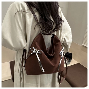 Détail d'un grand sac cabas marron avec nœuds argentés et texture en daim de luxe