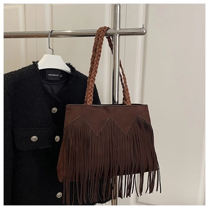 Detail of dark brown suede tote bag with long fringe and thick braided shoulder strap