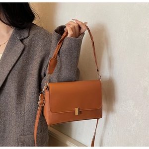 Sac bandoulière marron en similicuir avec poignée tressée et détails dorés sur mannequin