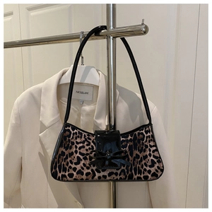 Close-up of leopard print baguette bag with black patent leather bow and shoulder strap