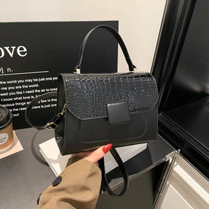 Black flap crossbody bag with crocodile pattern texture and top handle for women