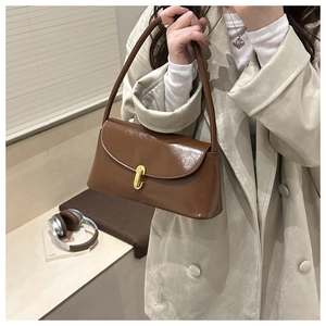 Detailed close-up of the vintage brown underarm bag with glossy finish and gold metal clasp