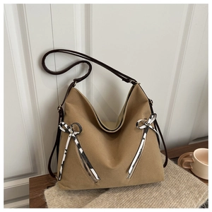 Détail du sac hobo terreux avec fermetures éclair symétriques et ruban décoratif