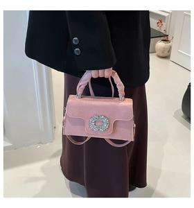 Detail of pink suede handbag featuring a luxury rhinestone buckle and fine texture