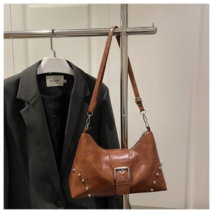 Close-up of brown vintage PU leather tote featuring silver rivets and metal buckle detail