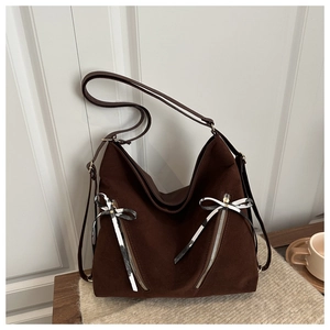 Détail d'un sac cabas café noir avec fermetures éclair et nœuds de ruban stylés