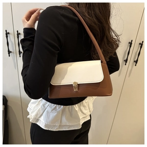 Détail du sac baguette rétro avec rabat blanc et bandoulière en cuir marron chic