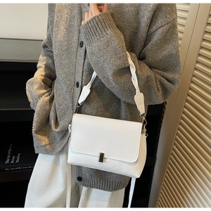Détail du sac bandoulière en cuir blanc avec poignée tressée et fermoir en métal
