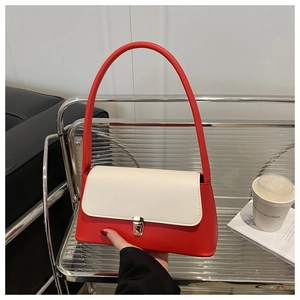 Detail of red and white faux leather underarm bag with elegant gold metal lock buckle