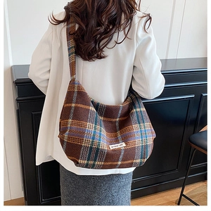Detailed macro shot of vintage brown plaid crossbody bag fabric and power off label