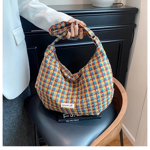 Detail of colorful woolen tweed texture and power off label on retro shoulder bag