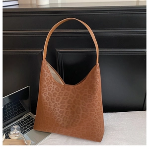 Detailed close-up of brown leopard print pattern and PU leather texture on hobo tote bag