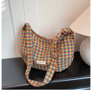 Detailed view of colorful houndstooth fabric and power off label on a crescent bag