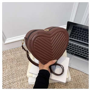 Detail of dark brown heart-shaped crossbody bag with V-quilted texture and zipper closure
