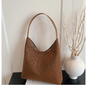 Detail of vintage leopard print tote bag on a desk with minimalist artistic decor