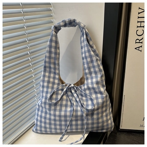Close-up of blue gingham tote bag featuring a decorative bow tie and soft fabric texture