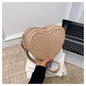 Detail of heart-shaped quilted crossbody bag with V-shaped stitching and zipper closure