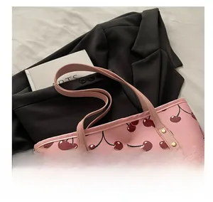 Vue détaillée d'un sac cabas rose avec imprimés cerises et poignées en cuir