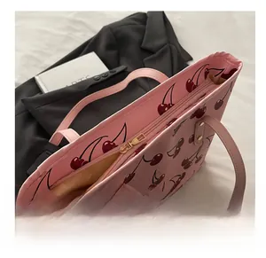 Détail du sac cabas rose avec imprimé cerise et fermeture éclair en métal doré lisse