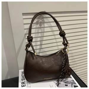 Close-up of deep brown leather bag with retro lychee texture and unique knot strap detail
