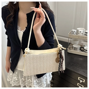 Detail of cream woven shoulder bag with V-pattern texture and elegant plaid silk scarf