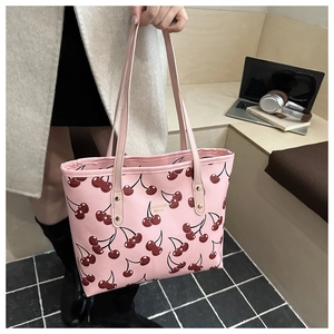 Close-up of pink tote bag with cherry prints and golden Fashion Bags lettering