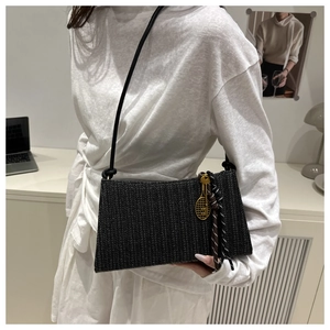 Detail of black woven rectangular shoulder bag with tennis racket charm and silk scarf