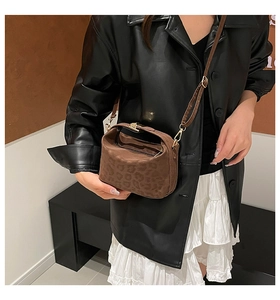 Detail of small leopard print suede crossbody bag with gold metal buckle and strap
