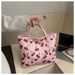Detailed view of pink tote bag with cherry prints and durable leather-like PU texture