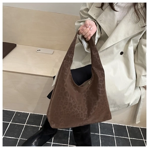 Close-up of leopard print tote bag styled with a beige trench coat for a chic look