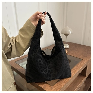 Detail of black leopard print jacquard tote bag with textured fabric and slouchy design