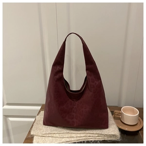 Detail of burgundy leopard print hobo bag in soft suede fabric on a cozy scarf
