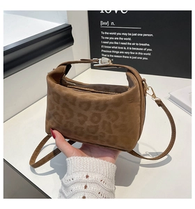 Detail of leopard print handbag showing compact texture and gold metallic hardware
