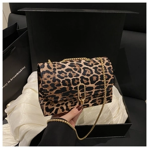 Gros plan du sac à main léopard avec boucle dorée sur tissu en soie dans un coffret