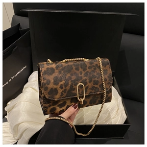 Détail du sac léopard avec bandoulière chaîne dorée dans un coffret cadeau élégant